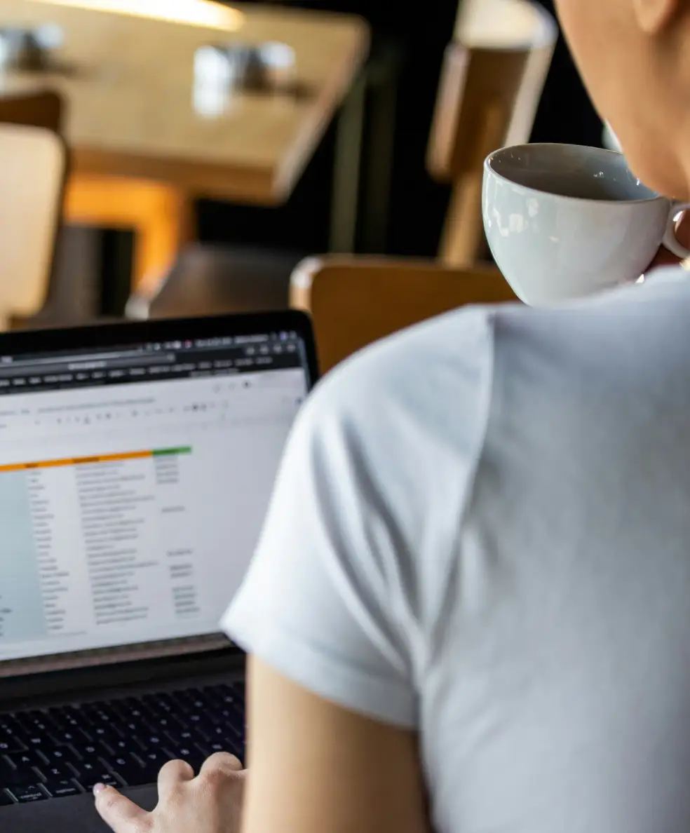 Photo of business owner looking over orders in spreadsheet