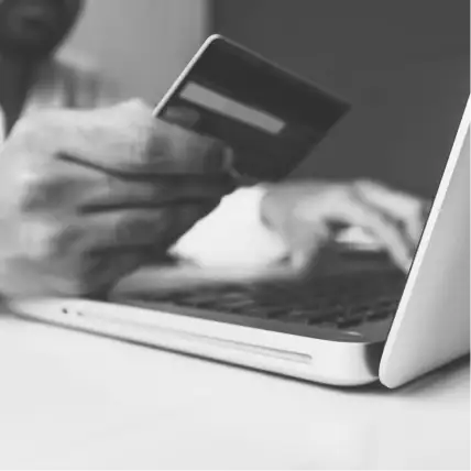 Photo of person holding credit card purchasing online